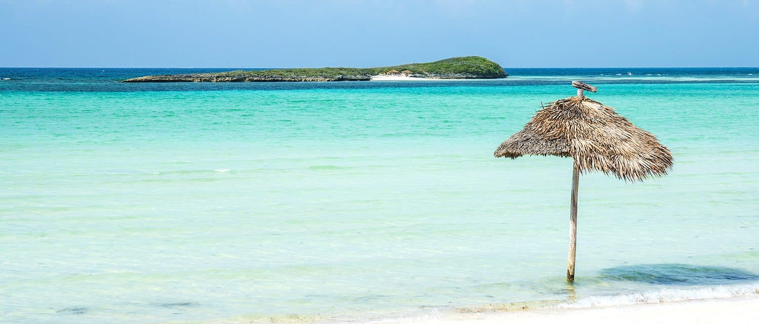A thatched umbrella on a quiet beach in the Abacos