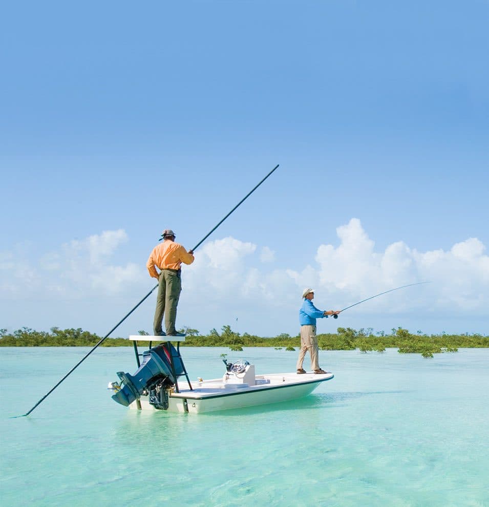 A guide poling a skiff across the bonefishing flats of Andros