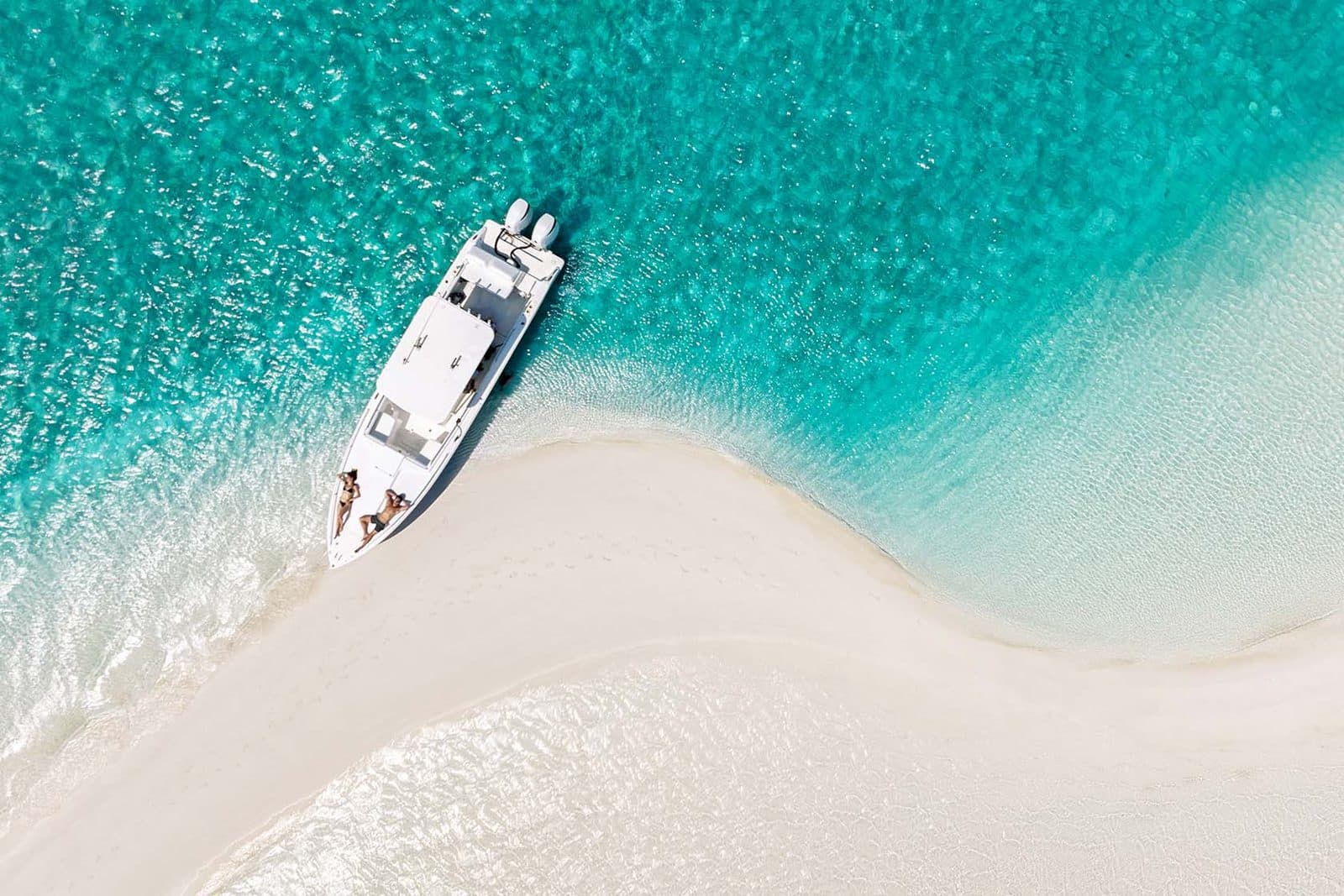 A boat pulled up to a sandbar in the Exuma Cays, seen from above